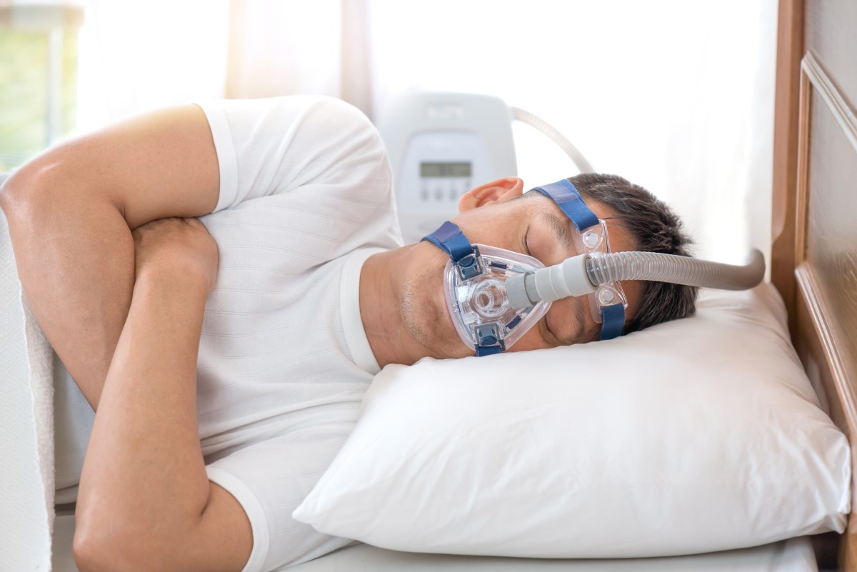 Masker CPAP di wajah seorang pria dengan apnea tidur