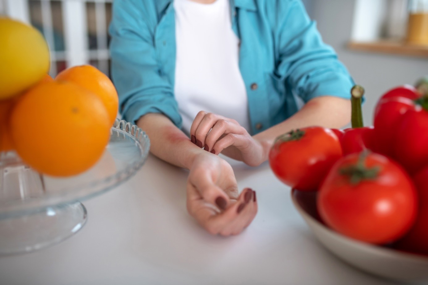 Wanita mengalami gatal-gatal setelah makan buah atau sayuran? Dia menggaruk lengan bawahnya