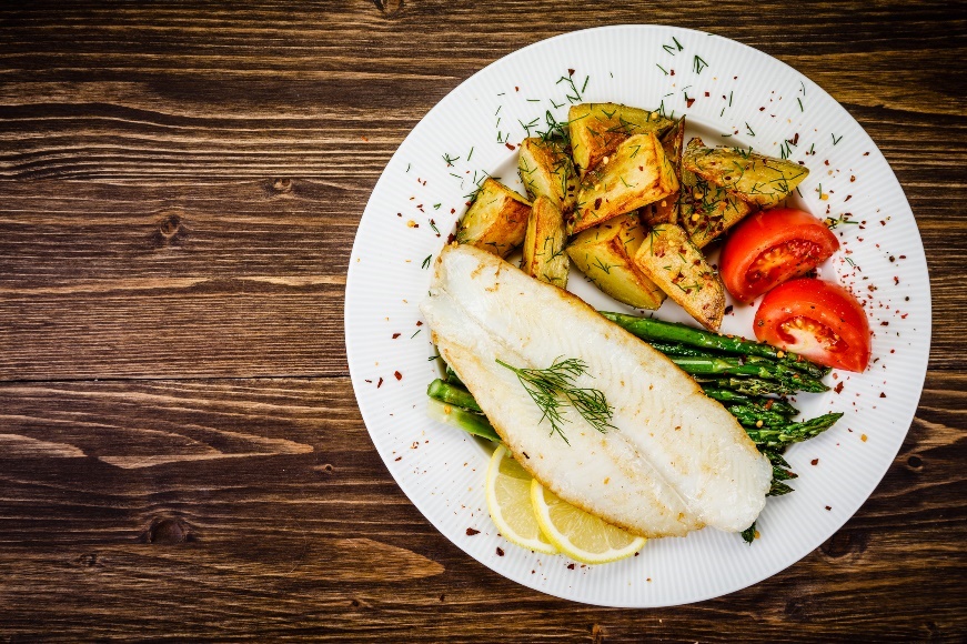 Contoh makan malam: ikan bakar dengan asparagus, kentang panggang, bumbu dan sayuran segar.